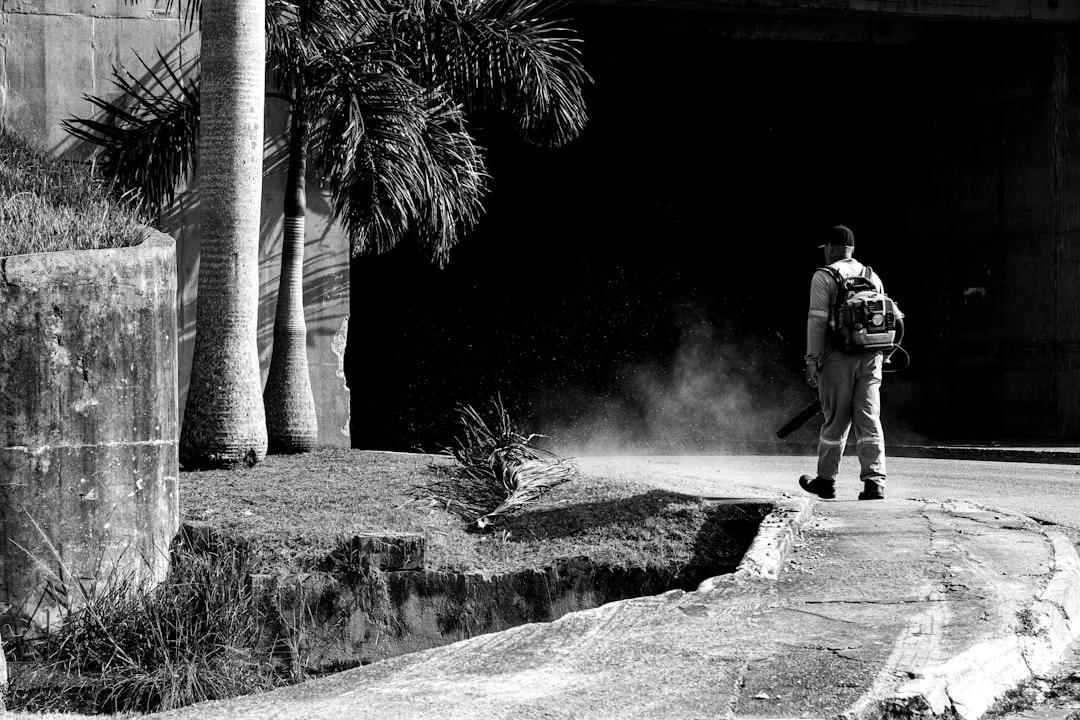 team-04 Person in protective suit disinfecting a white table indoors with a sprayer.